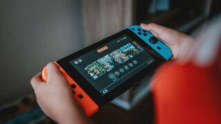person holding black and orange nintendo switch